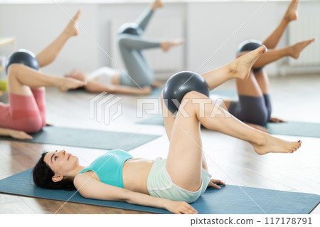 Group of young women doing pilates with softball Group of young women doing pilates with softball 117178791