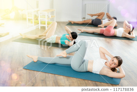 Group of young women doing pilates exercises Group of young women doing pilates exercises 117178836