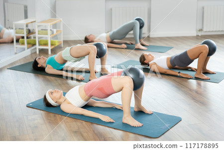 Young girls practicing bridge position with soft ball 117178895