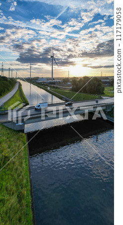 Aerial view of a highway over a water canal during sunrise, with traffic moving along Aerial view of a highway over a water canal during sunrise, with traffic moving along 117179058