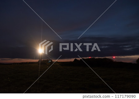 Camping under an evening sky with bright lights and red beacons is serene in the wilderness Camping under an evening sky with bright lights and red beacons is serene in the wilderness 117179090