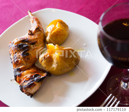 Baked in oven quarter of rabbit, served with pototoes at plate 117179110
