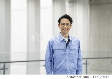 A portrait of a man in his thirties wearing work clothes looking at the camera A portrait of a man in his thirties wearing work clothes looking at the camera 117179816