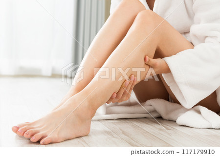 Woman massaging her legs. 117179910