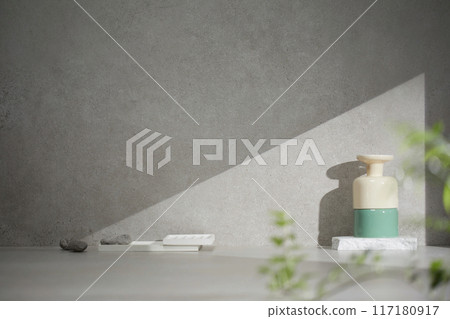 A gray-toned tile background with various props with sunlight coming through the window. 117180917