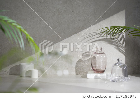 A gray-toned tile background with various props with sunlight coming through the window. A gray-toned tile background with various props with sunlight coming through the window. 117180973