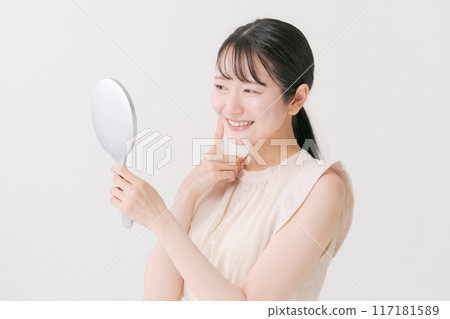 年輕女子看著鏡子微笑 117181589