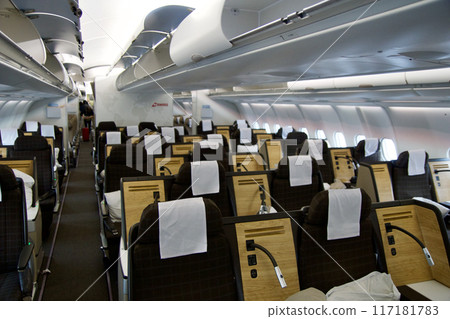 ZURICH, SWITZERLAND - JUNE 22, 2019: Empty cabin with business class seats with wood applications and brown fabric in a long-haul aircraft on the flight from Dubai to Zurich ZURICH, SWITZERLAND - JUNE 22, 2019: Empty cabin with business class seats with wood applications and brown fabric in a long-haul aircraft on the flight from Dubai to Zurich 117181783