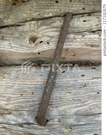 Old wooden log wall. Logs are connected by a metal clamp. Old wooden log wall. Logs are connected by a metal clamp. 117182879