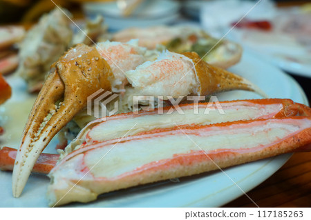 Steamed crab legs on a white plate in a restaurant Steamed crab legs on a white plate in a restaurant 117185263