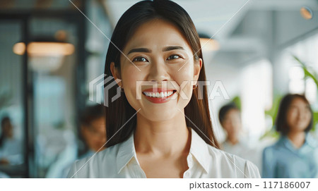 A young asian beautiful smile senior manage woman. wear cream smart shirt. friendly leader posing in office. Positive leader A young asian beautiful smile senior manage woman. wear cream smart shirt. friendly leader posing in office. Positive leader 117186007