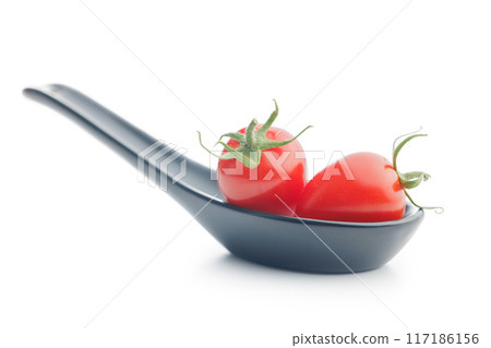 Red cherry tomatoes in ceramic spoon isolated on white background. Red cherry tomatoes in ceramic spoon isolated on white background. 117186156