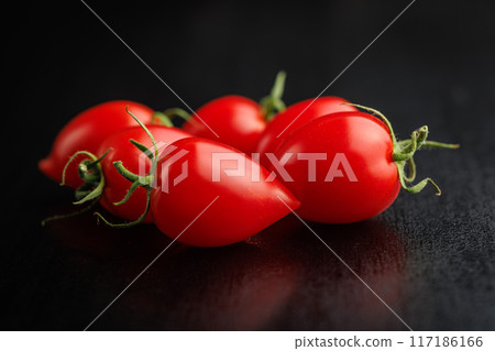 Red cherry tomatoes on black table. Red cherry tomatoes on black table. 117186166