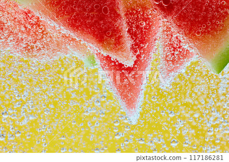 Fizzy bubbles surround watermelon slices, highlighting their juicy, refreshing appeal against vibrant, colorful backdrop. 117186281
