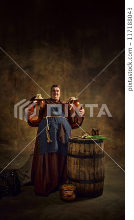 Medieval monk proudly holding two large ale jugs, symbolizing rich tradition of monastic brewing, against vintage background. 117188043