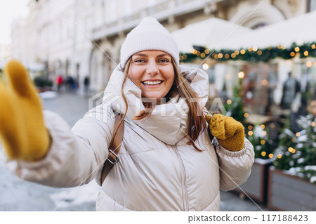 Happy 30s woman taking selfie on winter snowy day. Winter holidays banner. Concept of vacations, holidays and happiness Christmas. High quality photo Happy 30s woman taking selfie on winter snowy day. Winter holidays banner. Concept of vacations, holidays and happiness Christmas. High quality photo 117188423