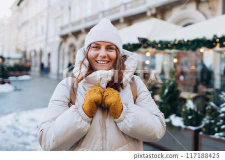 Happy 30s woman posing on urban background on winter snowy day. Winter holidays banner. Concept of vacations, holidays and happiness Christmas. High quality photo Happy 30s woman posing on urban background on winter snowy day. Winter holidays banner. Concept of vacations, holidays and happiness Christmas. High quality photo 117188425