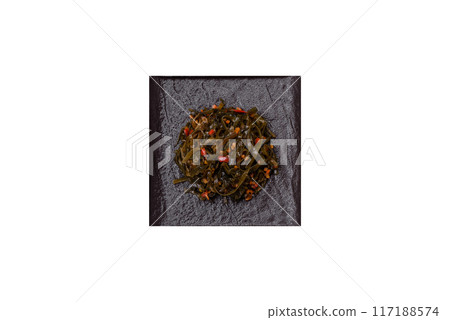 Delicious marinated seaweed with paprika, spices and salt on a dark concrete background Delicious marinated seaweed with paprika, spices and salt on a dark concrete background 117188574