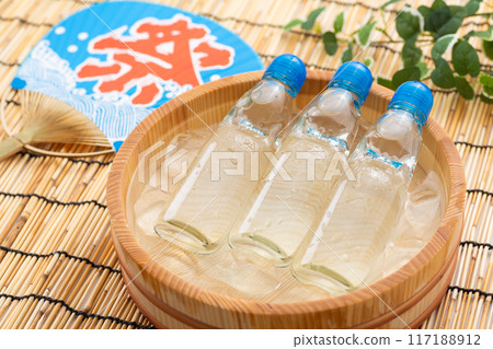 汽水在一桶水和冰以及節日扇子中冷卻 117188912