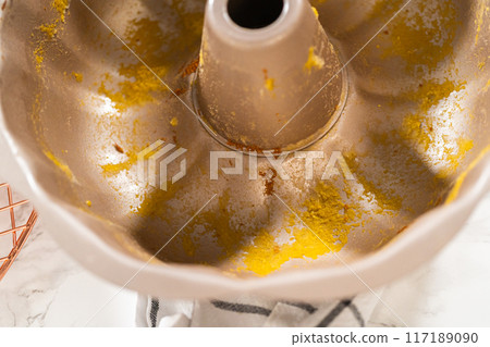 A close-up view of a dirty bundt cake pan after baking the pumpkin bundt cake. 117189090