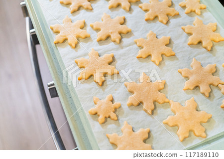 Letting delightful snowflake-shaped sugar cookies cool after baking, preparing them for festive Christmas gifts. Letting delightful snowflake-shaped sugar cookies cool after baking, preparing them for festive Christmas gifts. 117189110