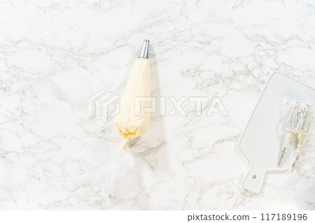 Flat lay. Preparing cream cheese frosting to ice the delicious pumpkin bundt cake. Flat lay. Preparing cream cheese frosting to ice the delicious pumpkin bundt cake. 117189196