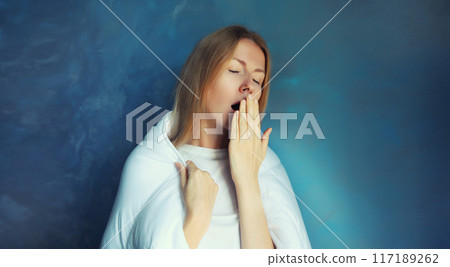 Sleepy lazy young woman yawns wakes up after sleep in blanket in morning at home Sleepy lazy young woman yawns wakes up after sleep in blanket in morning at home 117189262