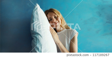 Healthy sleep, happy relaxed sleepy young woman lying on white soft comfortable pillow 117189267