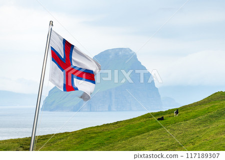 National Faroese flag waving against a background of green hills National Faroese flag waving against a background of green hills 117189307