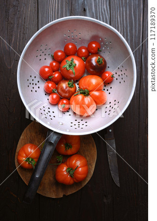 Top view on ripe red tomatoes in rustic metal colander Top view on ripe red tomatoes in rustic metal colander 117189370