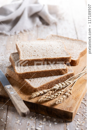 Healthy wholemeal bread slices on rustic wooden table 117189507