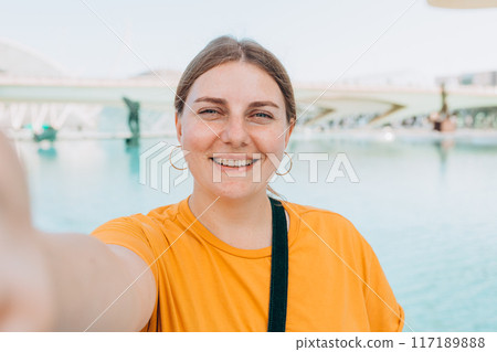 Young traveling woman taking selfie outdoors. Concept of travel, tourism and vacation in city. Ciudad de las Artes y las Ciencias de Valencia.Valencia City of Arts and Sciences. High quality photo Young traveling woman taking selfie outdoors. Concept of travel, tourism and vacation in city. Ciudad de las Artes y las Ciencias de Valencia.Valencia City of Arts and Sciences. High quality photo 117189888