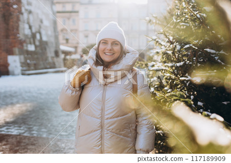 Happy 30s woman posing on urban background on winter snowy day. Winter holidays banner. Concept of vacations, holidays and happiness Christmas. High quality photo Happy 30s woman posing on urban background on winter snowy day. Winter holidays banner. Concept of vacations, holidays and happiness Christmas. High quality photo 117189909