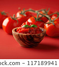 Promotional poster of tomato paste in a small wooden bowl, foreground, red background 117189941