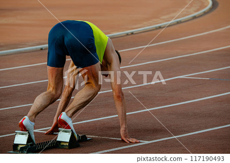male runner in starting blocks sprint race male runner in starting blocks sprint race 117190493