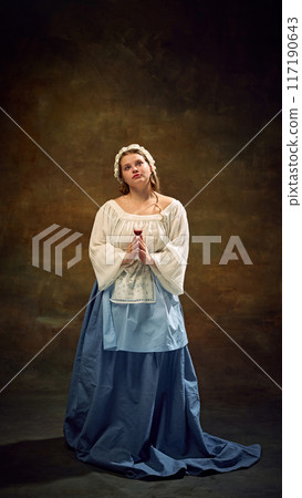 Cubby woman in traditional dress stands gracefully, holding glass of wine, her expression serene against vintage background. Festive celebration with elegance. Cubby woman in traditional dress stands gracefully, holding glass of wine, her expression serene against vintage background. Festive celebration with elegance. 117190643
