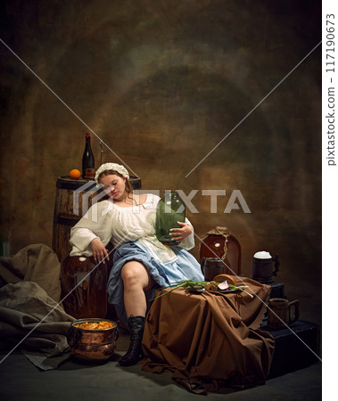 Woman in traditional attire relaxes with jug in hand, surrounded by rustic items like barrels, and simple food in tranquil, homely atmosphere. Woman in traditional attire relaxes with jug in hand, surrounded by rustic items like barrels, and simple food in tranquil, homely atmosphere. 117190673