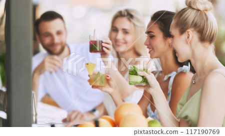 bar vibes. Happy,smiling young people, man and woman enjoying refreshing drinks, delicious cocktail in modern outdoor bar. Cheers 117190769