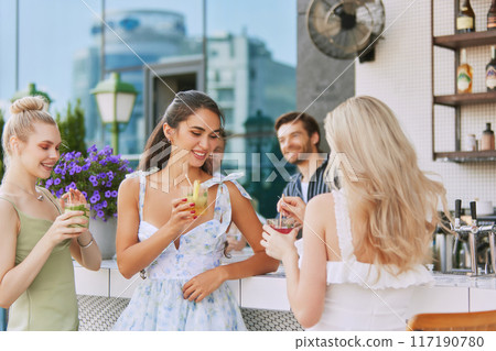 Happy beautiful young women, friends meeting in luxury outdoor bar, enjoying conversations and cocktails. Birthday celebration Happy beautiful young women, friends meeting in luxury outdoor bar, enjoying conversations and cocktails. Birthday celebration 117190780