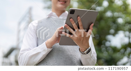 Business Professional Using Tablet Outdoors for Modern Work Solutions and Digital Communication 117190957