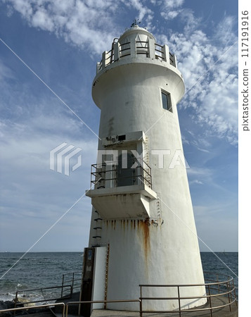 lighthouse sticking out into the sea 117191916