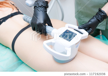 A woman is getting a body contouring treatment 117192036