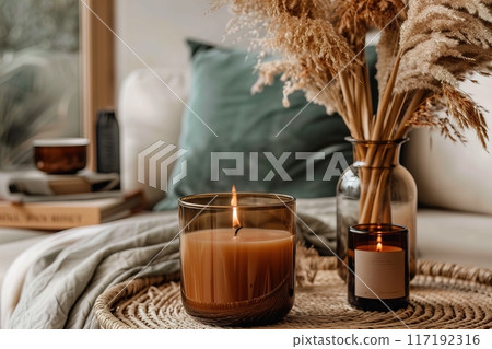 Create a cozy atmosphere in your living space with candles and dried flowers for a warm ambiance 117192316