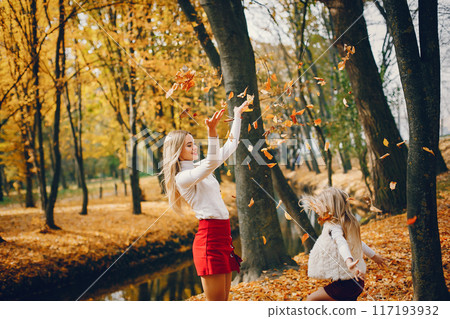 Fashionable mother with daughter. Family in a autumn park. Fashionable mother with daughter. Family in a autumn park. 117193932