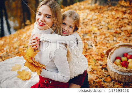 Fashionable mother with daughter. Family in a autumn park. 117193938