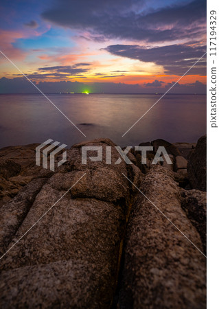 Long exposure image of Dramatic sky seascape with rocks and waves crashing on seashore in sunset or sunrise scenery background Long exposure image of Dramatic sky seascape with rocks and waves crashing on seashore in sunset or sunrise scenery background 117194329