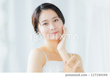 A young woman feels her skin become more moisturized A young woman feels her skin become more moisturized 117194349