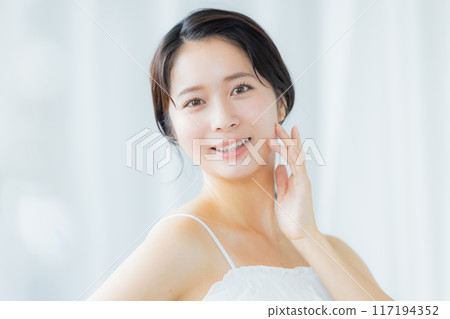 A young woman feels her skin become more moisturized 117194352