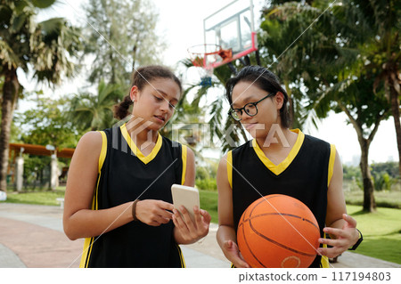 Basketball Players Examining Smartphone During Game Break Basketball Players Examining Smartphone During Game Break 117194803