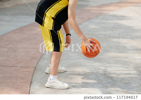 Dribbling Basketball on Outdoor Court, Bright Summer Day 117194817